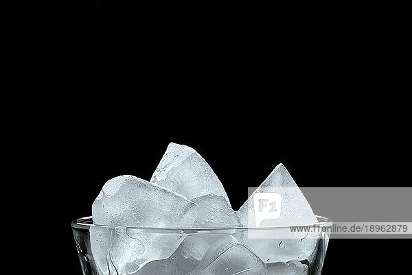 Eiswürfel in einem Glas  auf schwarzem Hintergrund