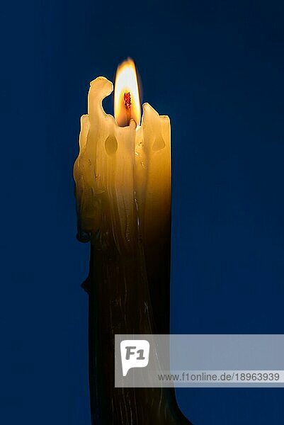 Eine Kerze mit einer Flamme in der blaün Nacht