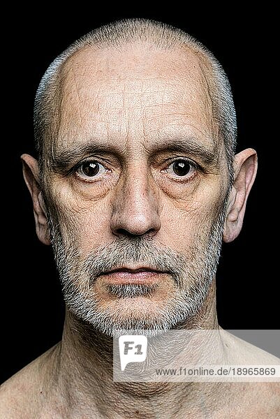 Dramatisches Farbporträt eines erwachsenen Mannes mit traurigem Gesichtsausdruck auf schwarzem Hintergrund