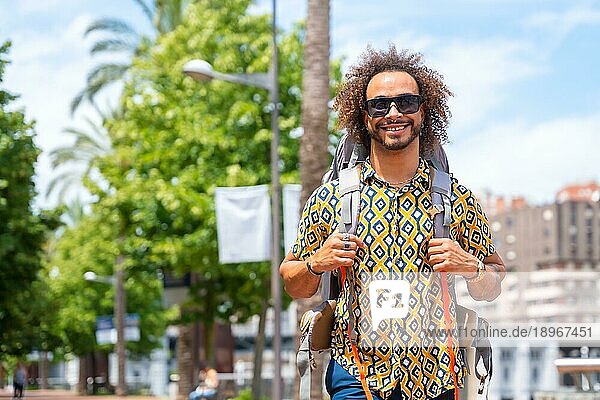 Afrohaar Mann auf Rucksacktour im Sommerurlaub  Lebensstil außerhalb eines Touristen auf Reisen
