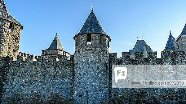 The Château Comtal  Count’s Castle  is a medieval castle in the Cité of Carcassonne  tall towers and wall.
