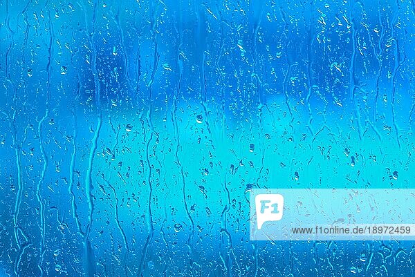 Frisches Wasser auf einem blaün Fenster an einem regnerischen Tag