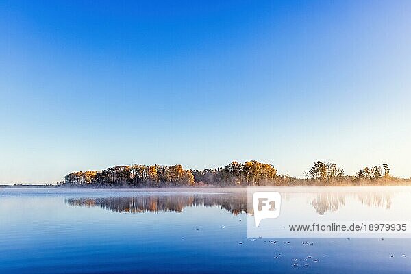 Landschaftlicher Blick auf einen ruhigen See mit Wasserspiegelungen im Herbst  Schweden  Europa