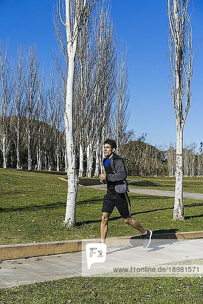 Junger attraktiver Sportler Sportler Läufer joggt am Morgen im öffentlichen Park. Raum kopieren