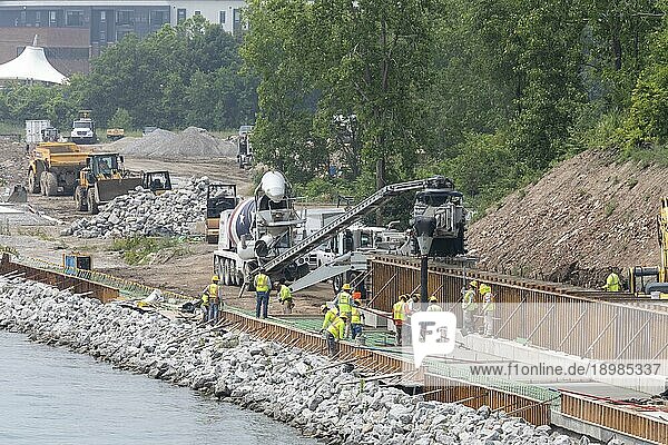 Arbeiter gießen Zement  um einen Abschnitt des Detroit Riverwalk auf dem Gelände der ehemaligen Uniroyal Reifenfabrik fertigzustellen. Der Wander und Radweg entlang des Detroit River wurde zum besten Flussweg Amerikas gekürt
