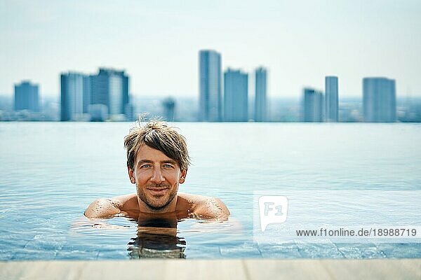 Hübscher Mann entspannt sich im Schwimmbad. Sommerurlaub Konzept
