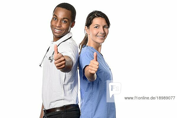 Enthusiastisches erfolgreiches multiethnisches medizinisches Team mit einem lächelnden afrikanischen Arzt und seiner hübschen Krankenschwester oder Assistentin  die mit einem glücklichen Lächeln die Daumen nach oben strecken  vor weißem Hintergrund