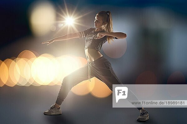 Full Length Shot eines jungen weiblichen Hip Hop Tänzer mit Lichtern beleuchtet von hinten