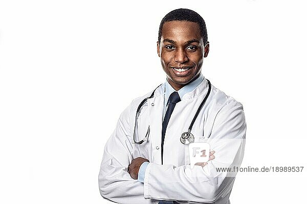 Attraktiver selbstbewusster männlicher afrikanischer Arzt in weißem Laborkittel und Stethoskop  der mit einem glücklichen Gesichtsausdruck in die Kamera schaut  Oberkörper vor weißem Hintergrundem Grund