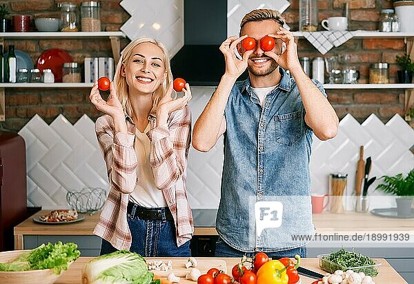 Glückliches lächelndes Paar hat Spaß beim gemeinsamen Kochen in der Küche zu Hause