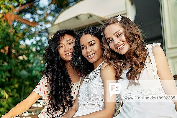 Schöne multiethnische Mädchen posieren in der Nähe von Wohnmobilen im Freien. Kaukasische  afroamerikanische und asiatische Mädchen haben Spaß zusammen während eines Picknicks. Frauen Freundschaft und Frauen Schönheit Konzept