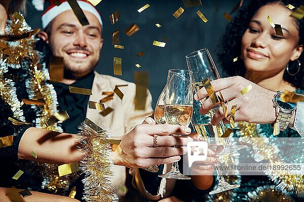 Multiethnische Freunde stoßen mit Champagner an  feiern Weihnachten oder Neujahr  gratulieren sich gegenseitig und genießen die Party. Feiern und Prost Konzept  Urlaub Hintergrund