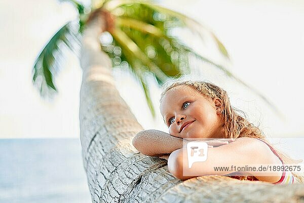 Glücklich träumen schönes Kind entspannen am tropischen Strand mit Palme. Sorglos Konzept