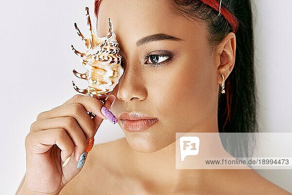Hübsche junge Afro Frau  die ihr Auge mit Muscheln bedeckt. Weibliche Schönheit  Spa  saubere Haut Konzept. Kopieren Raum
