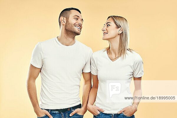 Junges glückliches Paar in der Liebe Blick zueinander über beige Hintergrund. Beziehung  Flirten Konzept