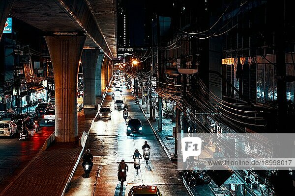 Autos und Motorräder auf einer nachts beleuchteten Straße  BANGKOK
