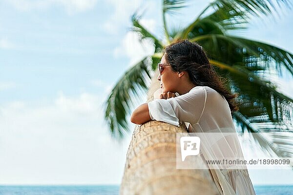 Träumende schöne Frau entspannen am tropischen Strand mit Palme. Sorglos Konzept