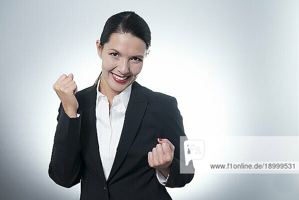 Schöne  jubelnde junge Geschäftsfrau  die mit einem strahlenden  begeisterten Lächeln im Gesicht einen Erfolg feiert  mit Kopiervorlage