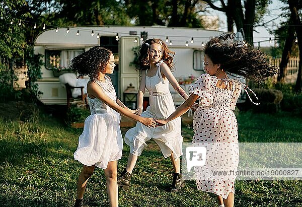 Glückliche schöne Frauen tanzen im Freien auf Picknick. Multi ethnische Mädchen haben Spaß zusammen im Sommer reist genießen Urlaub