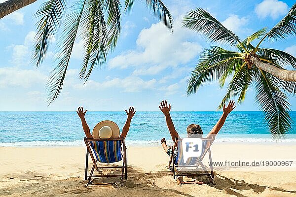 Glückliches Paar mit Armen oben entspannen am Strand genießen schönes Meer auf der tropischen Insel. Sommer Strandurlaub Konzept