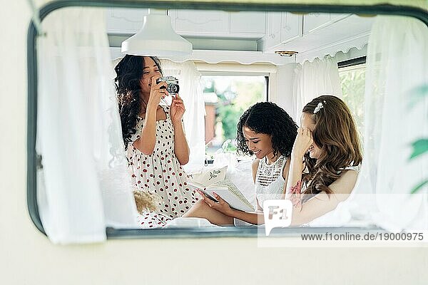 Schöne Frau macht Foto von ihren multiethnischen Freunden im Wohnmobil während ihrer Sommerreise. Mädchen haben Spaß