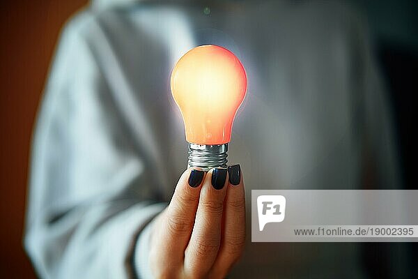 Frau hält leuchtende Glühbirne in der Hand. Neue Idee  Innovation und Inspiration Konzept