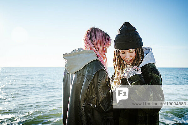 Lesbian couple standing near seashore
