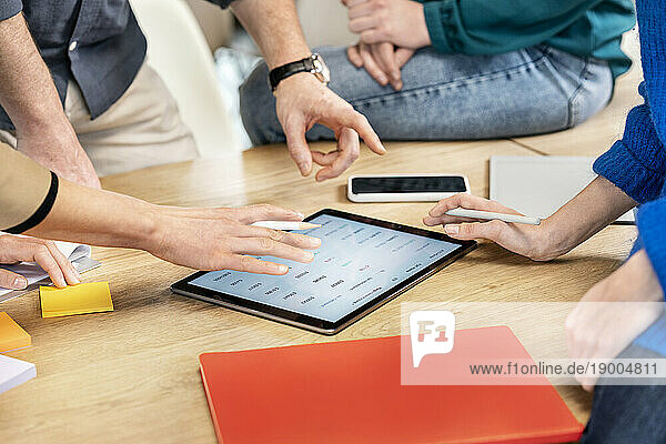 Colleagues having discussion over tablet PC on table