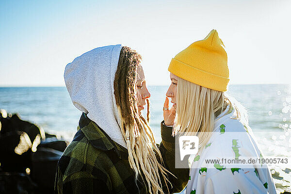 Romantic lesbian couple standing near sea