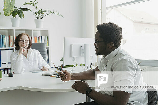 Patient discussing medical record with doctor in office