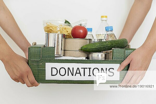 Freiwillige halten eine Kiste mit Lebensmittelspenden. Auflösung und hohe Qualität schönes Foto