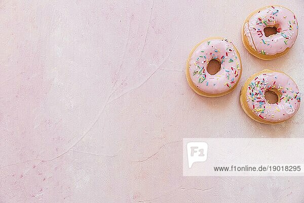 Overhead Ansicht frische Donuts mit Streuseln rosa Hintergrund. Auflösung und hohe Qualität schönes Foto