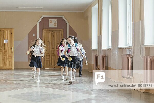 Fröhliche Kinder laufen durch den Schulflur. Schönes Foto