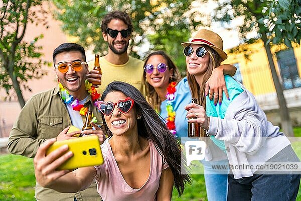 Multiethnische Gruppe von Freunden  die im Stadtpark feiern und ein Selfie machen  Freundschaft und Spaßkonzept mit Sonnenbrille auf einer Geburtstagsparty