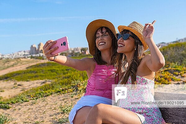 Frau Freunde mit Hut sehr glücklich im Urlaub am Strand nehmen ein Selfie mit dem Telefon  Freundschaft Konzept