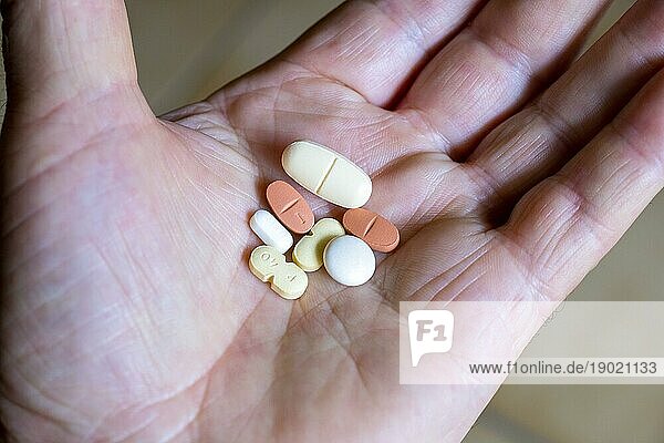 Hand hält verschiedene Tabletten  Medikamente  Arznei