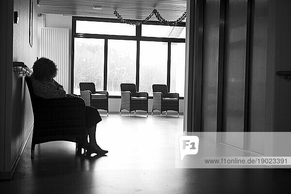 Elderly woman sitting in a retirement home.
