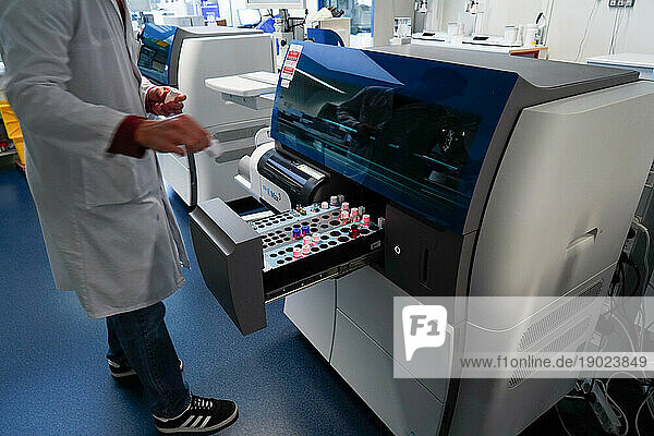 Technical platform of the Inovie 34 laboratory . A technician handling the Sta R Max 3 Analyzer to analyze blood coagulation and hemostasis.