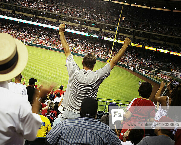 Rear view of a baseball fan raising his arms during a game at the Angel Stadium of Anaheim  California.