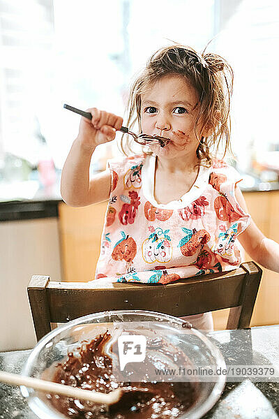 Toddler Girl Tasting Brownies in Kitchen