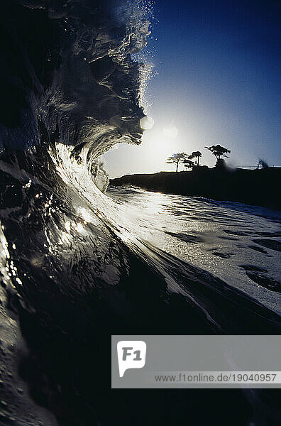 Side view of a high wave in the late afternoon shot from inside the water in Santa Cruz  California.
