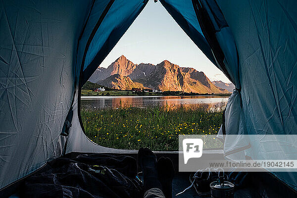 Man relaxing on a camping tent with a beautiful view