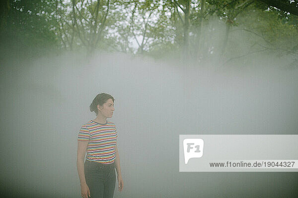 Young woman waiting in a foggy forest