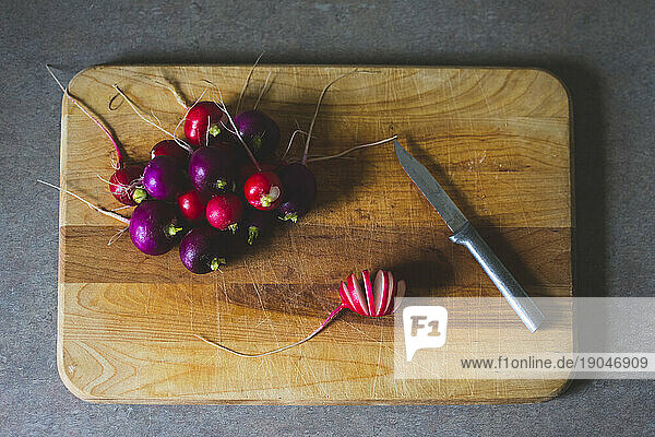 Fresh Radishes on a Wooden Cutting Board in a Kitchen