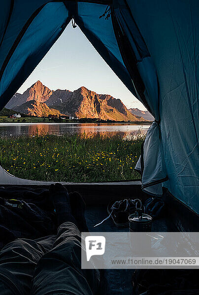 Man relaxing on a camping tent with a beautiful view