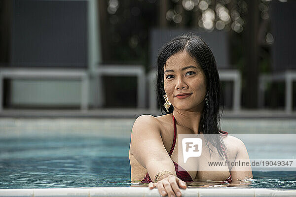 beautiful Thai woman relaxing by the pool