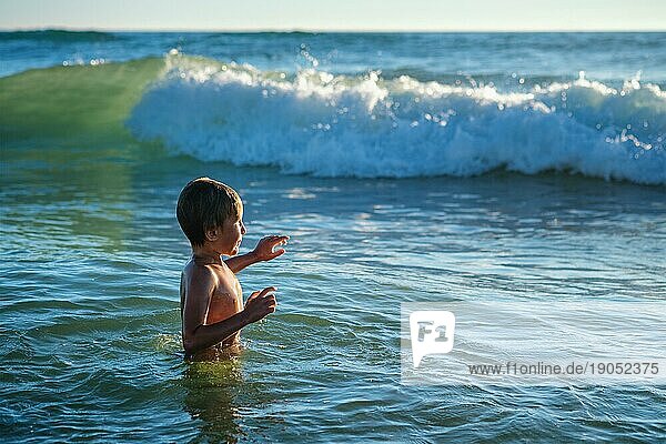 Junge hat Spaß genießt springt taucht in Ozean Meer Wellen des Atlantischen Ozeans. Strand Fonta da Telha  Costa da Caparica  Portugal  Europa