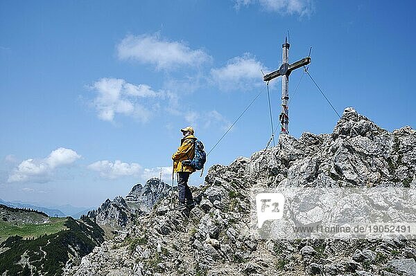 Wanderer  Senior  65  hält Gipfelrast am Wildalpjoch und genießt die Aussicht auf den Wendelstein  Bayrischzell  Sudelfeld  Mangfallgebirge  Oberbayern  Deutschland  Europa