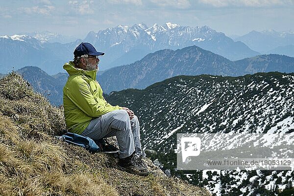 Wanderer  Senior  65  hält Gipfelrast an der Rotwand  hinten Wilder Kaiser  Spitzingsee  Mangfallgebirge  Oberbayern  Tirol  Deutschland  Österreich  Europa