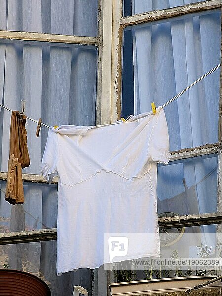 Wäsche zum Trocknen aufgehängt vorm Fenster  Hemd und Strümpfe